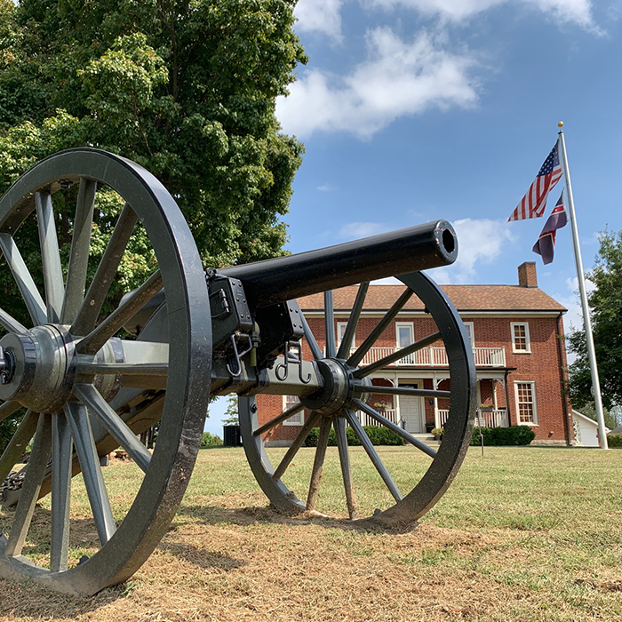 Cannon in front of a house with an American flag